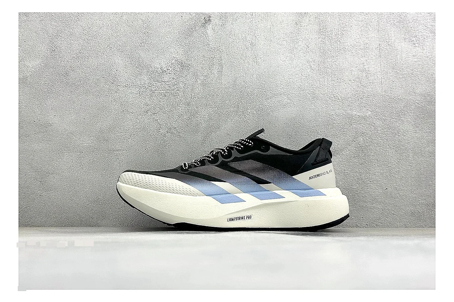 Adidas Adizero Evo Black comparison photo showing black racing upper, sculpted white sole, Adidas striping, and lightweight performance silhouette