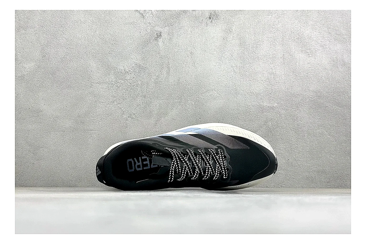 Adidas Adizero Evo Black comparison photo showing black racing upper, sculpted white sole, Adidas striping, and lightweight performance silhouette
