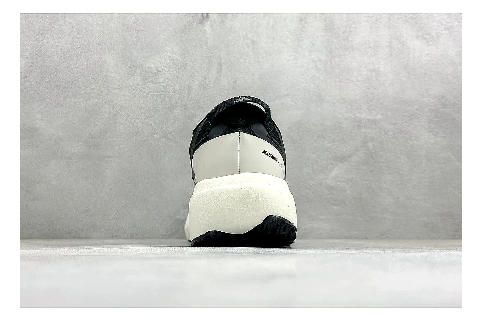 Adidas Adizero Evo Black comparison photo showing black racing upper, sculpted white sole, Adidas striping, and lightweight performance silhouette thumbnail 3