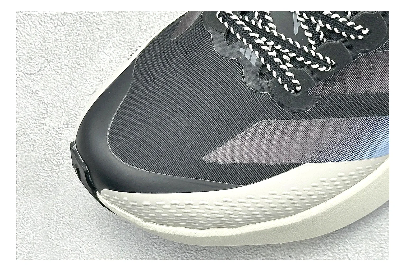 Adidas Adizero Evo Black comparison photo showing black racing upper, sculpted white sole, Adidas striping, and lightweight performance silhouette thumbnail 5