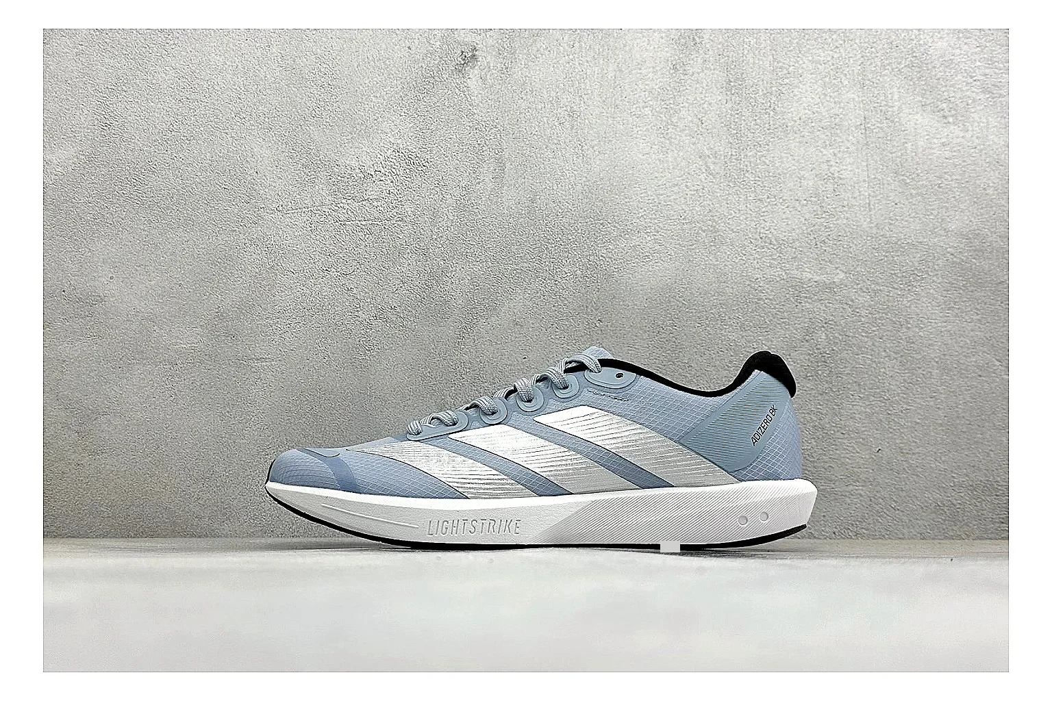 Adidas Adizero Grey Blue comparison photo showing grey lightweight runner upper, blue Adidas striping, slim racing shape, and low performance sole