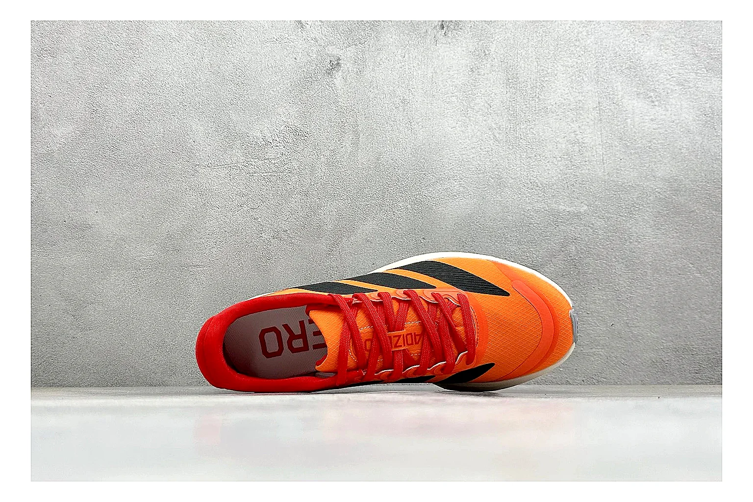Adidas Adizero Orange Black comparison photo showing orange runner upper, black three-stripe contrast, lightweight racing shape, and thin performance sole