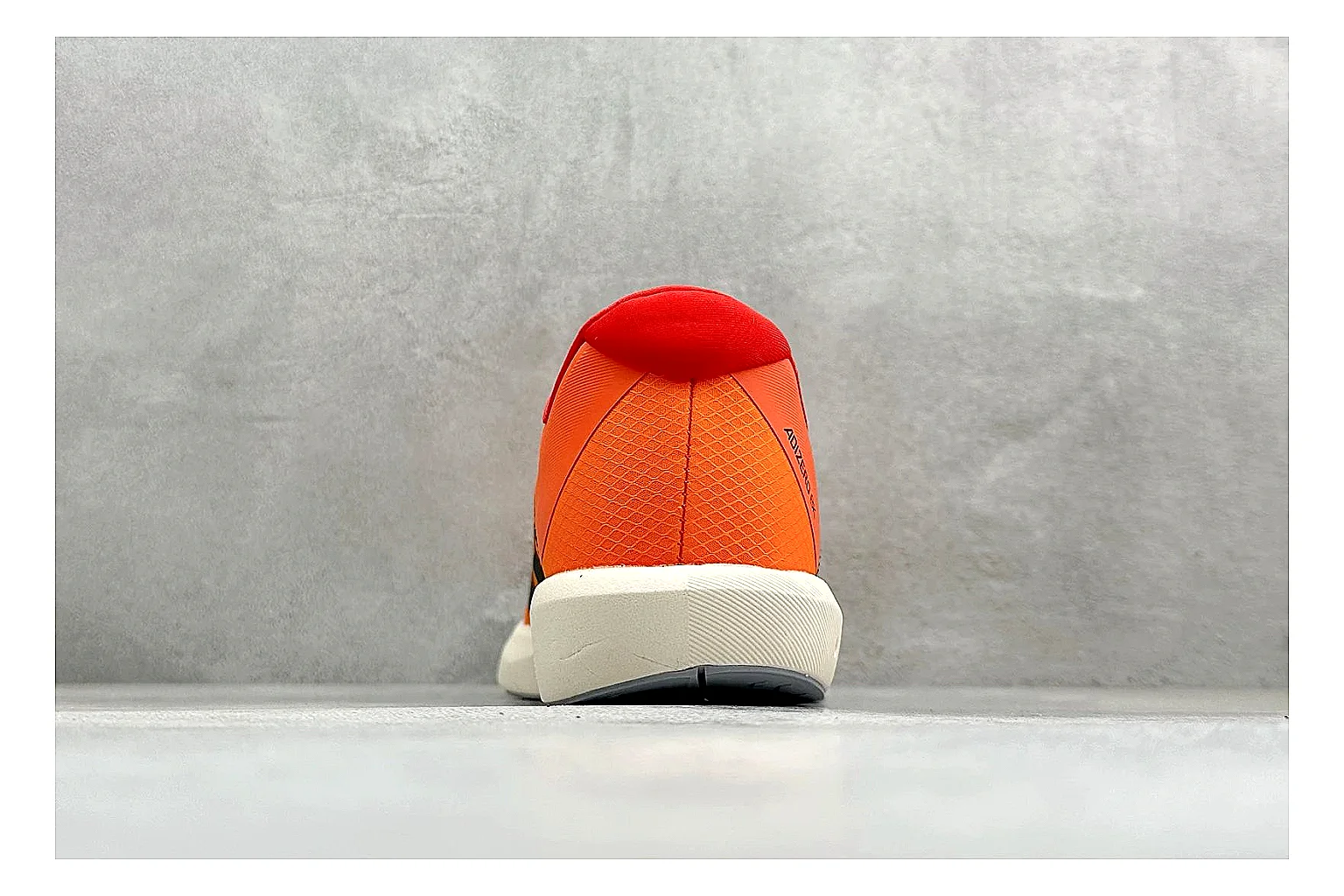 Adidas Adizero Orange Black comparison photo showing orange runner upper, black three-stripe contrast, lightweight racing shape, and thin performance sole thumbnail 3