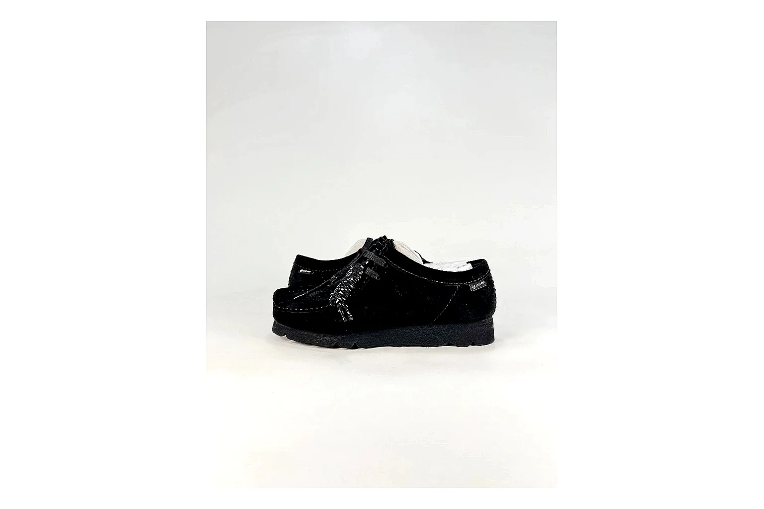 Clarks Wallabee Black Sneakers comparison signal photo with black suede Wallabee shoes with suede texture, side-profile shape, upper panel lines, and outsole detail
