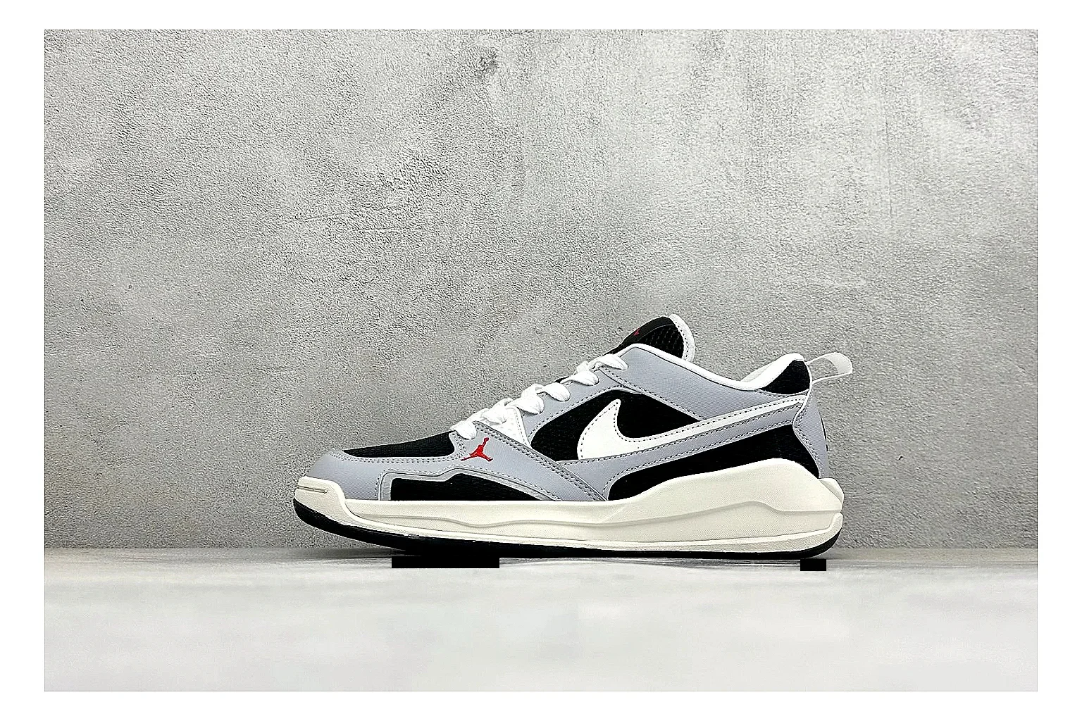 Jordan CMFT Black White comparison photo showing black and white layered panels, low padded collar, visible Jordan styling cues, and a compact court sole