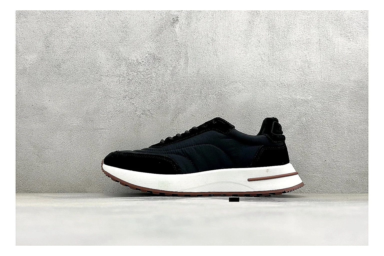 Loro Piana Week-End Black comparison image with black suede upper, low casual profile, striped midsole accent, and soft everyday shape