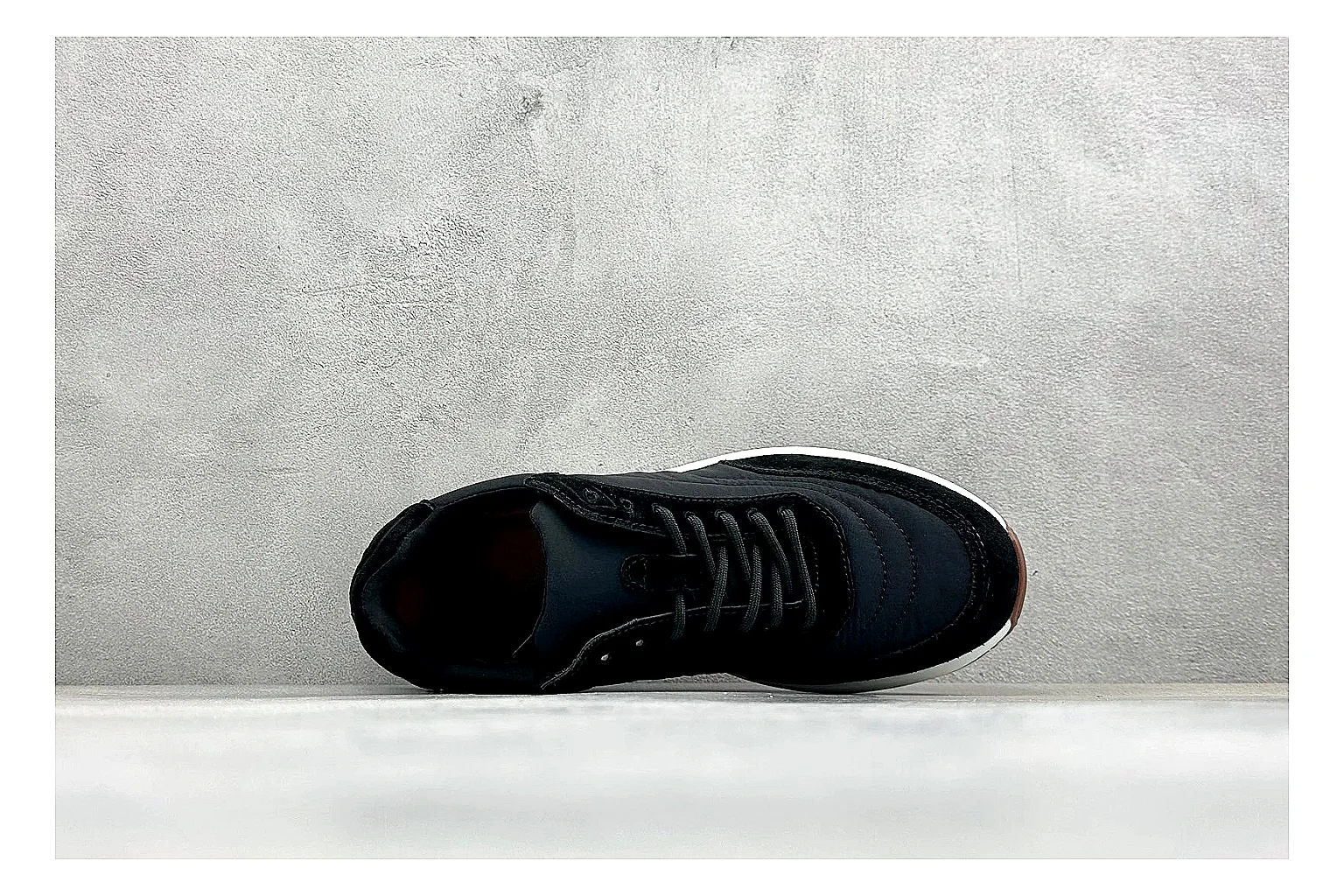 Loro Piana Week-End Black comparison image with black suede upper, low casual profile, striped midsole accent, and soft everyday shape