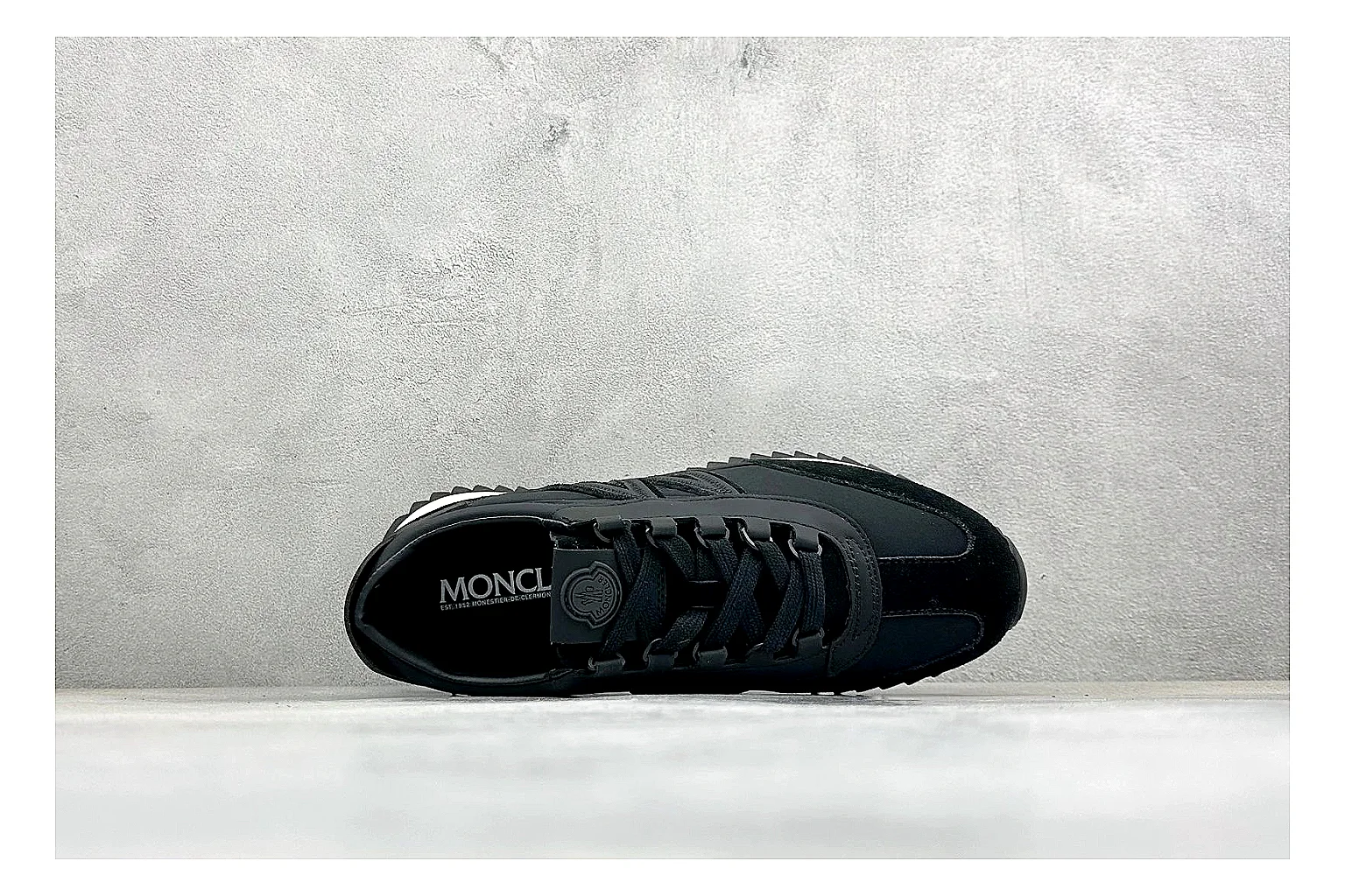 Moncler Pacey Black White comparison image with black upper, white rugged outsole, low padded collar, and outdoor-leaning tread profile