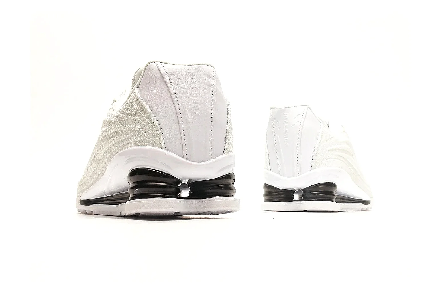 Nike Shox Z White Sneakers comparison photo showing white streamlined layered upper, small Swoosh, black heel cushioning columns, and modern low runner shape thumbnail 3