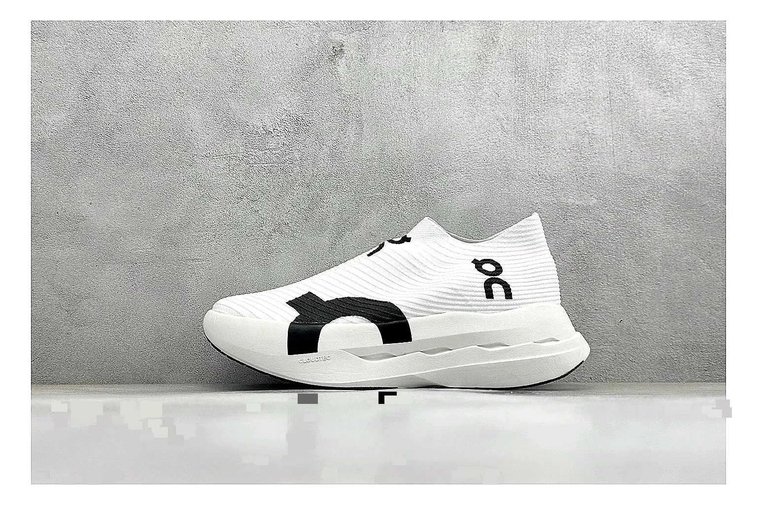 On Cloudboom White Black comparison photo showing white performance mesh, black contrast details, slim racing profile, and segmented CloudTec sole