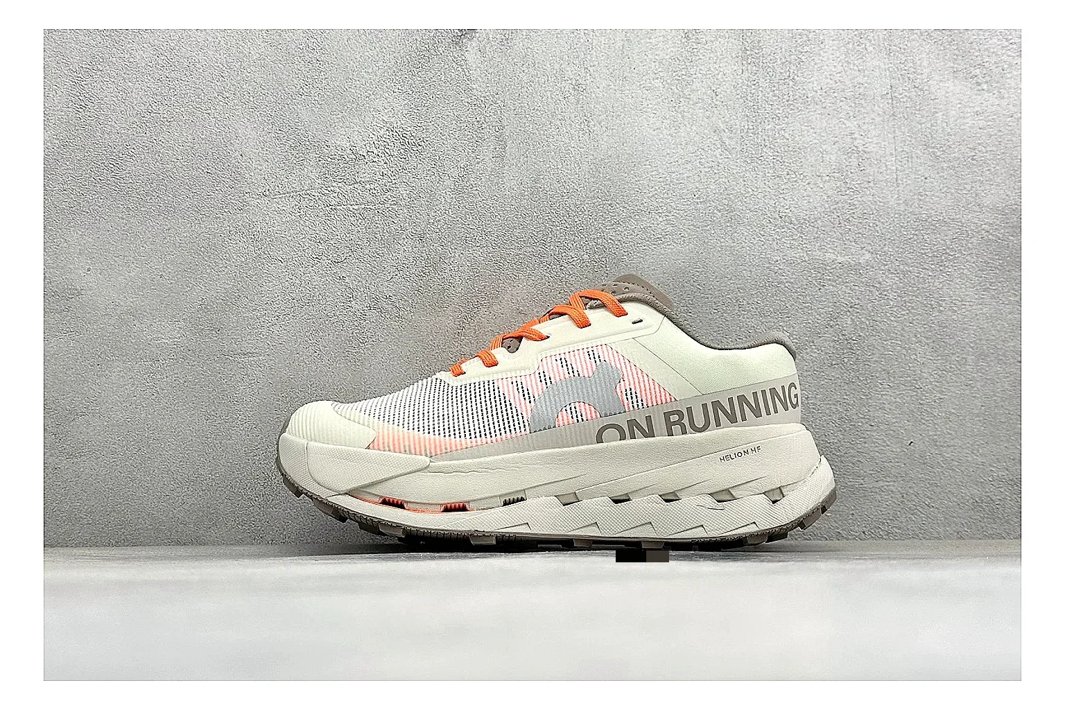 On Cloudmonster White Orange comparison photo showing white running mesh, orange accent hits, oversized CloudTec sole pods, and a rounded runner silhouette