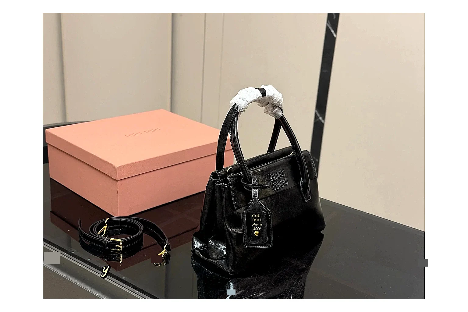 Prada Mini Top Handle Black comparison photo showing black leather mini bag body, structured top handle, compact luxury shape, and clean hardware details