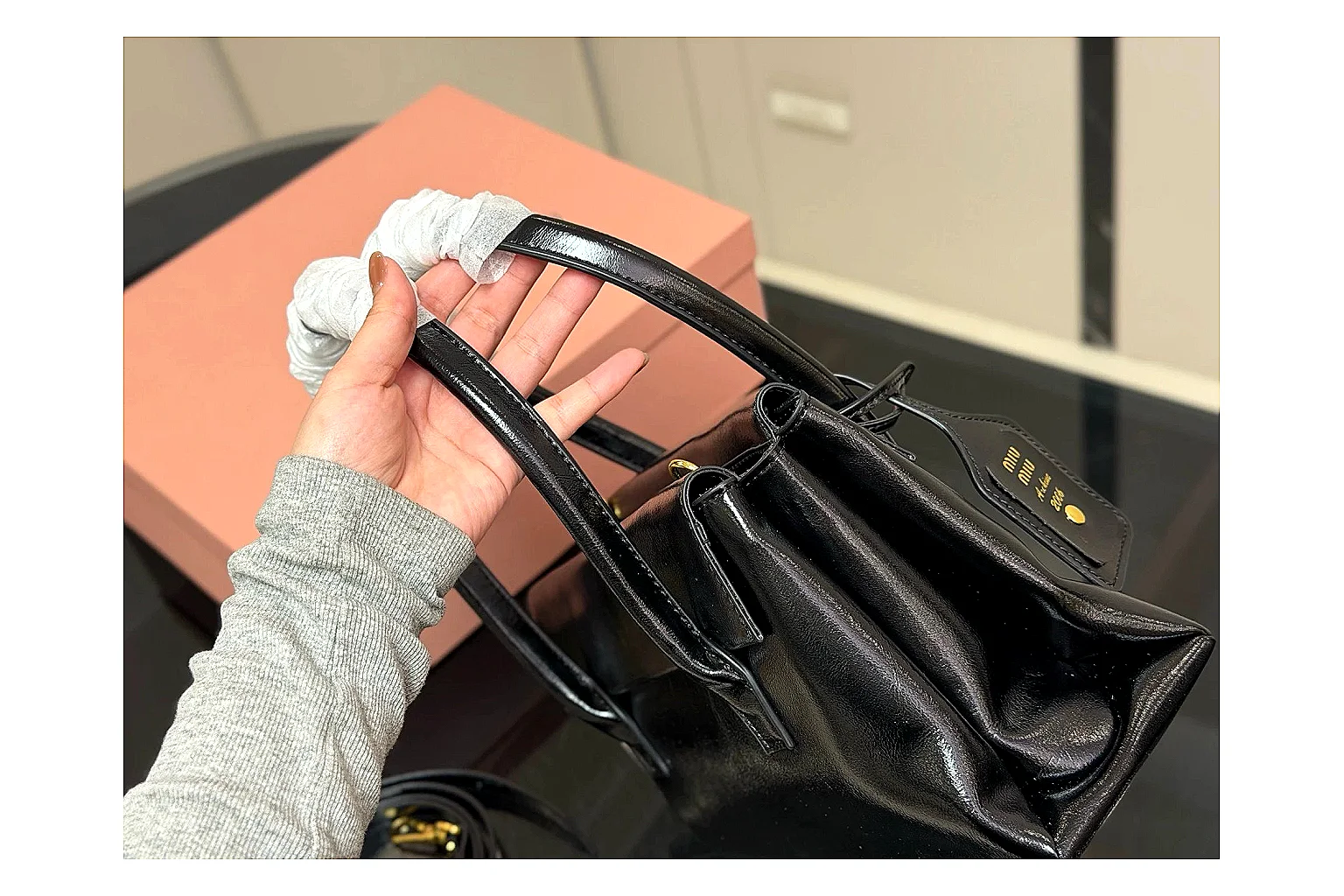Prada Mini Top Handle Black comparison photo showing black leather mini bag body, structured top handle, compact luxury shape, and clean hardware details thumbnail 5