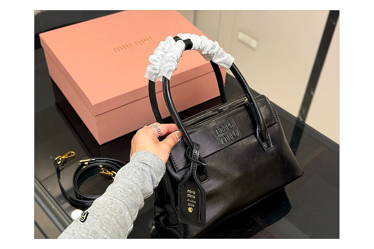Prada Mini Top Handle Black comparison photo showing black leather mini bag body, structured top handle, compact luxury shape, and clean hardware details thumbnail 6