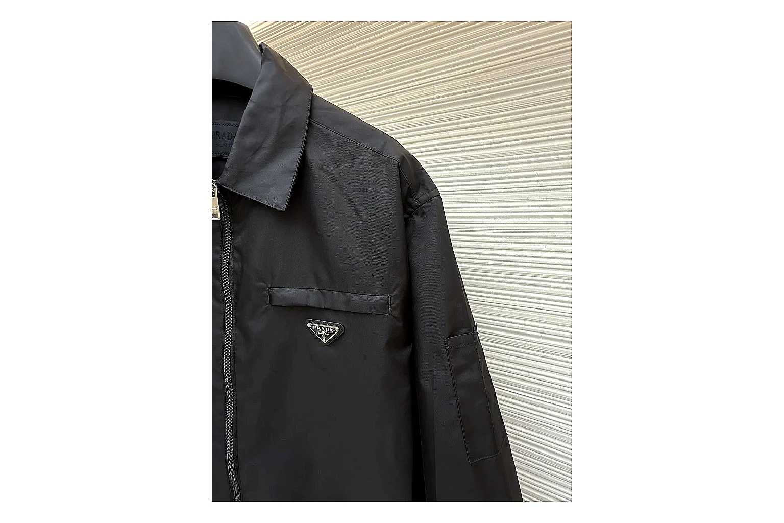 Prada Re-Nylon Hooded Jacket Black Jacket comparison signal photo with black Re-Nylon hooded jacket with recycled-nylon texture, hood structure, zipper line, sleeve cuffs, and light shell shape thumbnail 5